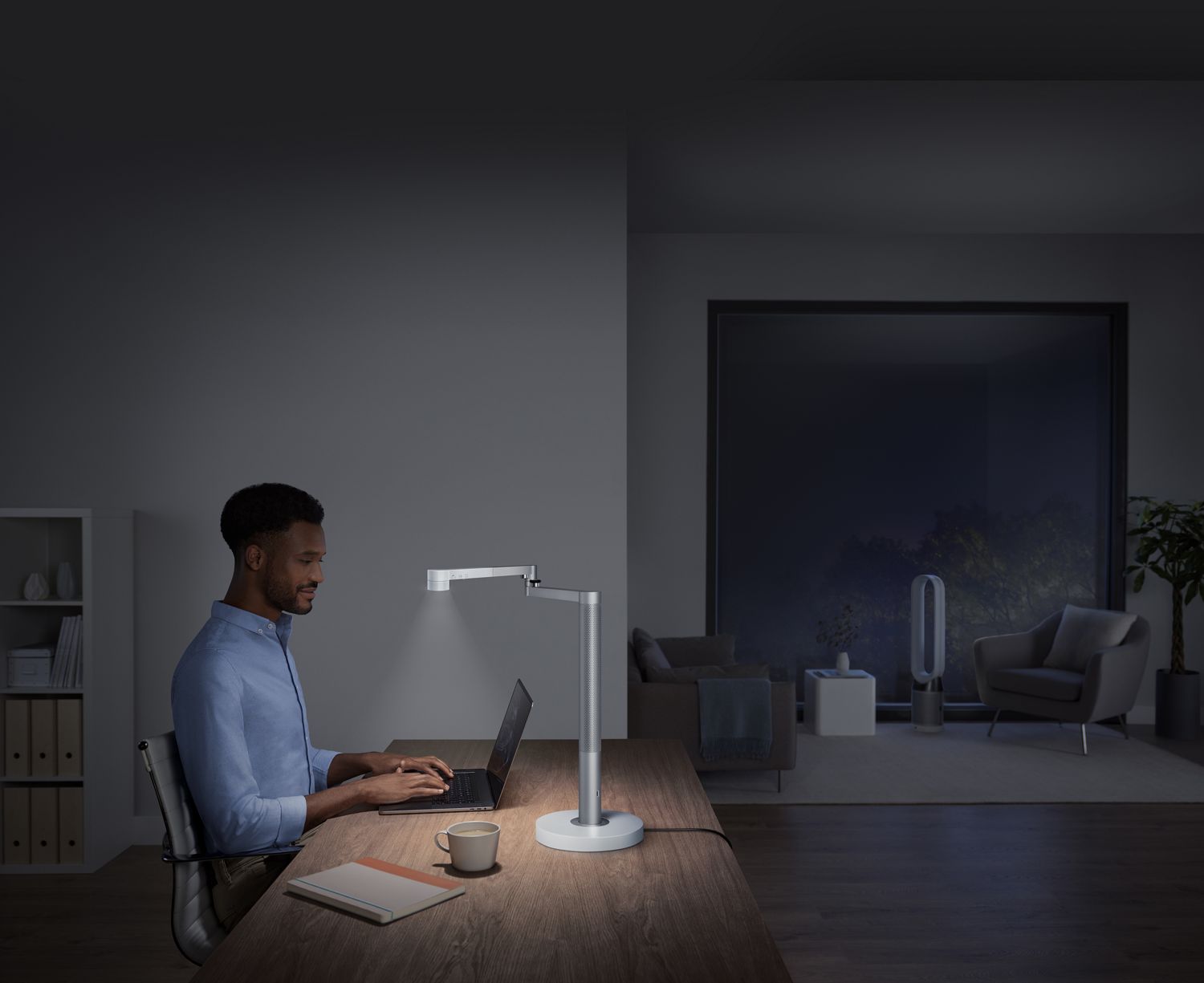 Un homme travaille sous un éclairage puissant.